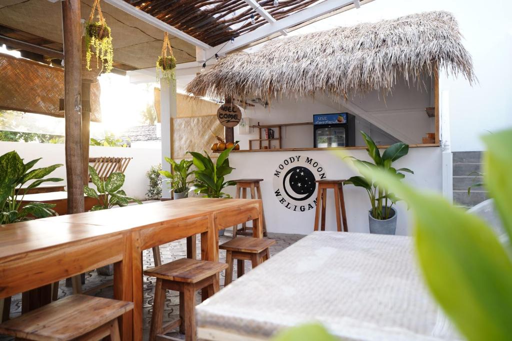 een restaurant met houten tafels, stoelen en planten bij Moody Moon Weligama in Weligama