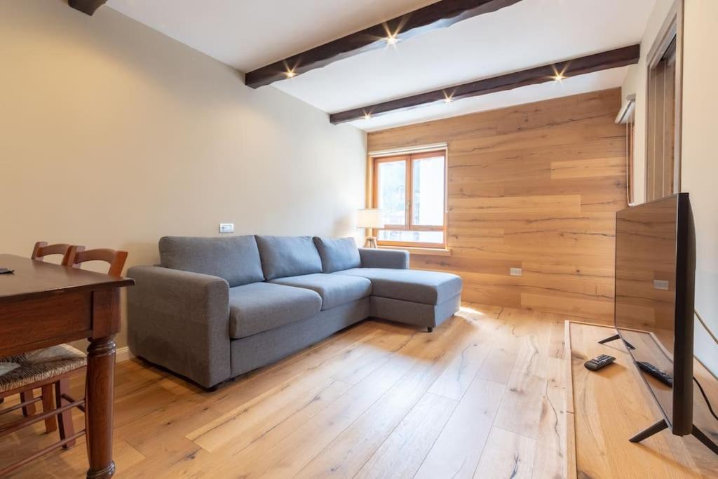uma sala de estar com um sofá e uma mesa em Bilocale vicino al Cretaz con posto auto - AS28 em Breuil-Cervinia