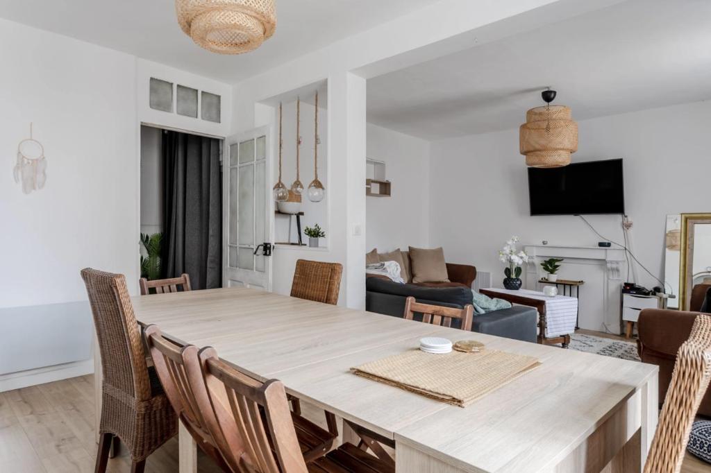 cocina y sala de estar con mesa de madera y sillas en Grande maison de ville proche de Disney, en Faremoutiers