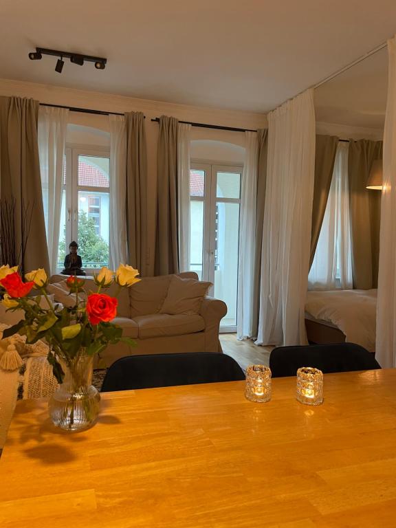 een woonkamer met een bank en een tafel met bloemen bij AnnApartment in Berlijn