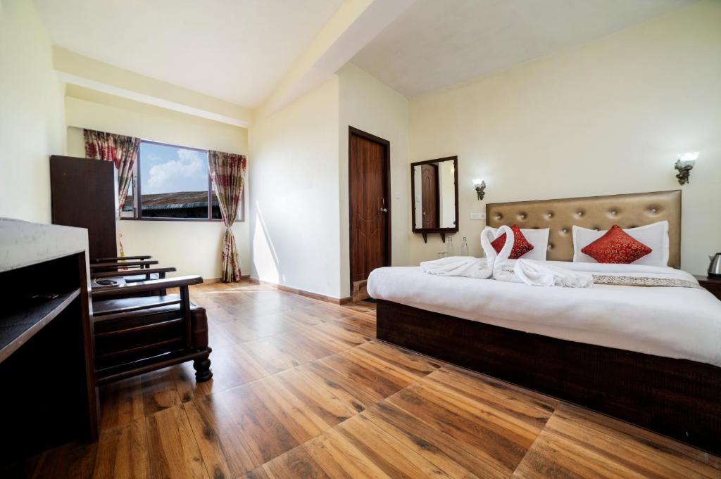 een hotelkamer met een groot bed en een piano bij Montis Ridhi Sidhi Residency in Darjeeling