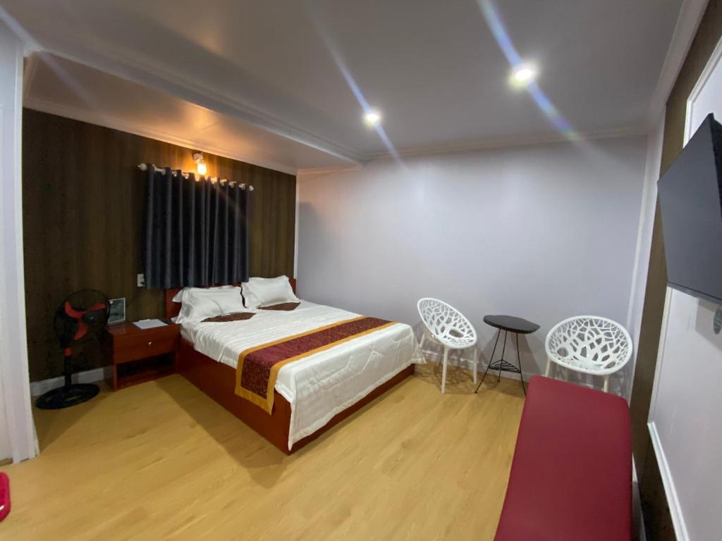 Schlafzimmer mit einem Bett, einem Tisch und Stühlen in der Unterkunft Motel Happy House in Bạc Liêu