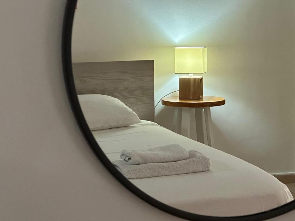 a bedroom with a bed with a mirror on it at King's Holiday Apartments in Paphos City