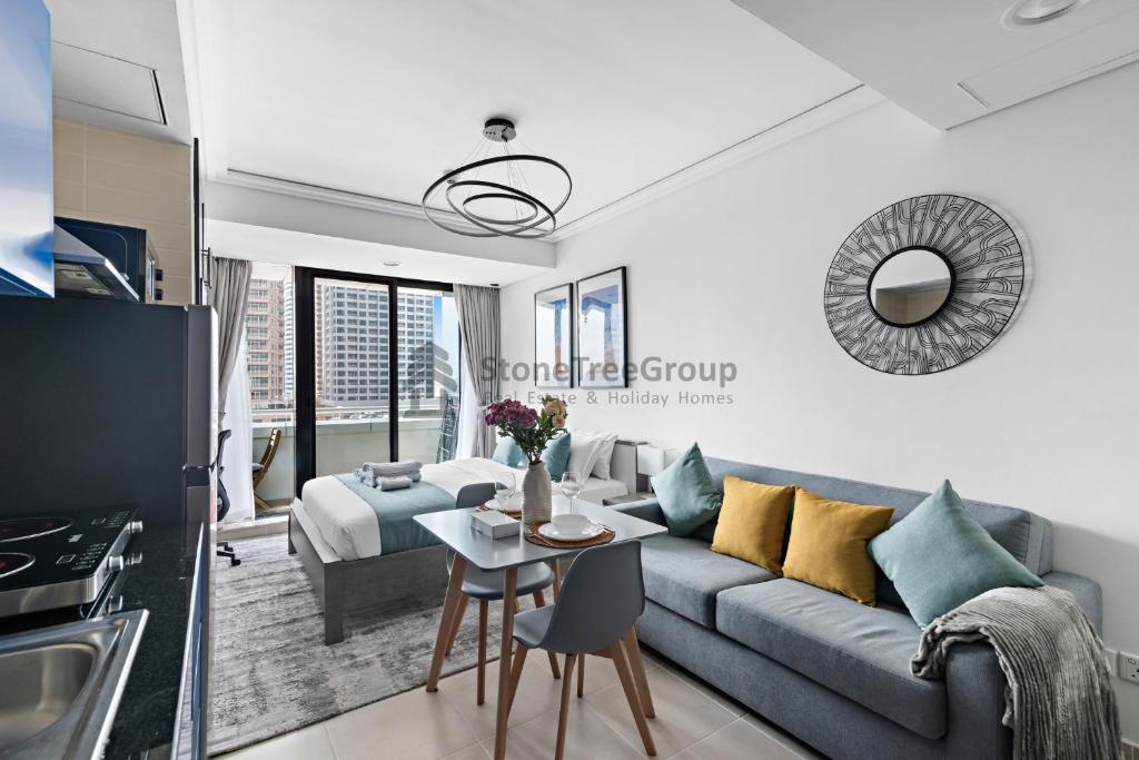 a living room with a couch and a table at StoneTree - New Studio in JLT in Dubai