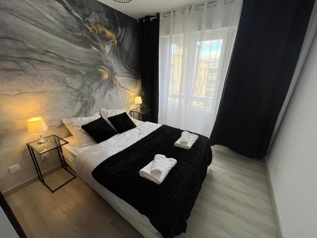 une chambre avec un grand lit avec deux serviettes dessus dans l'établissement Le Cannois, Appartement de star 3 chambres, à Mulhouse