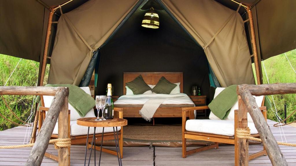 a bedroom in a tent with a bed and a table at Nujoum Overnight Camp with Signature Desert Safari in Dubai