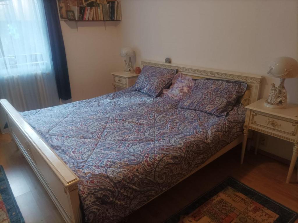 Ce lit se trouve dans une chambre dotée de 2 tables de chevet et de 2 tables. dans l'établissement Apartament Ana Cetate, à Alba Iulia