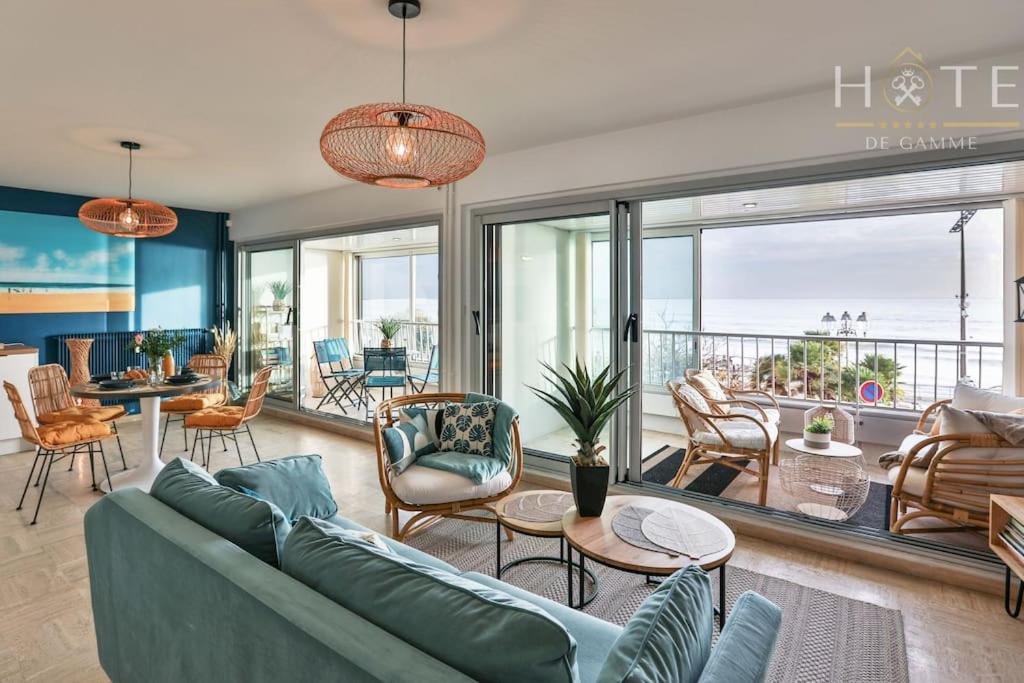 uma sala de estar com um sofá e cadeiras em Appartement central, vue mer époustouflante. em Les Sables-dʼOlonne