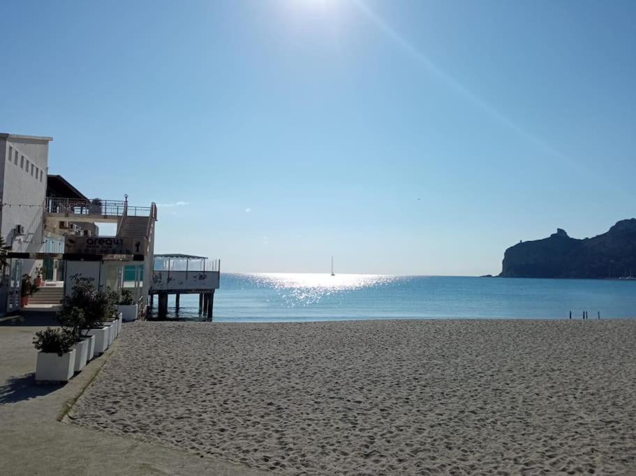 een uitzicht op een strand met een pier en de oceaan bij Lella's Home in Quartu SantʼElena