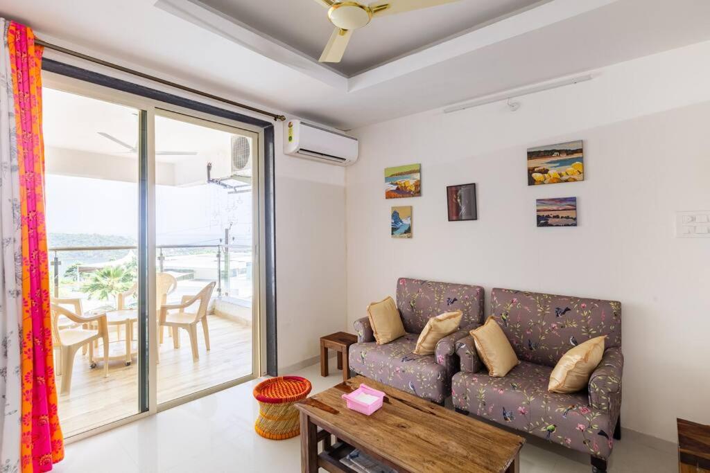 Marmagao的住宿－1 BHK Sunrise & Seaside Solitude，客厅配有沙发和桌子