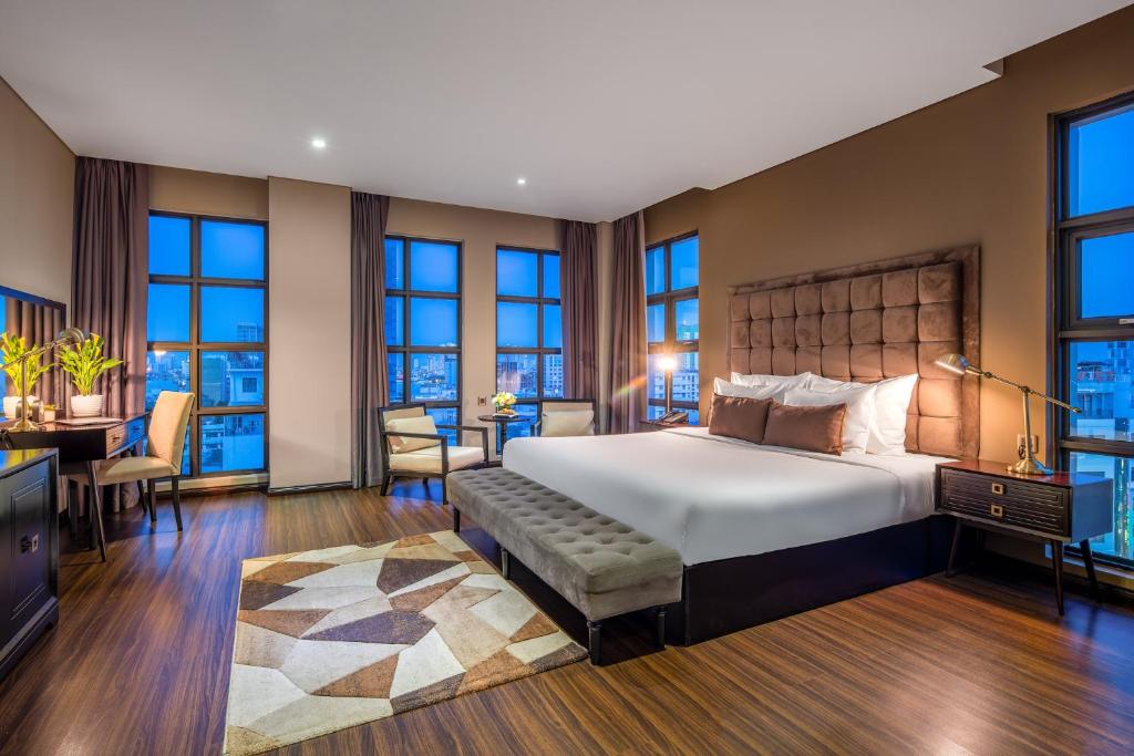 ダナンにあるサヌバ ダ ナン ホテルのベッドルーム(大型ベッド1台、デスク付)