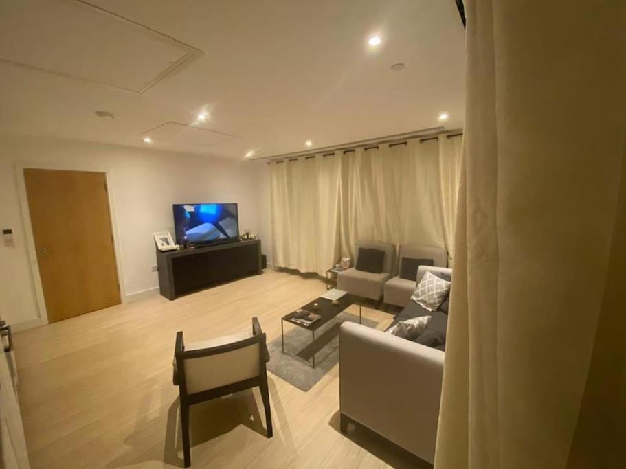 Luxury 2 bed ensuite 2 bathroom apartment East Croydon في South Norwood: غرفة معيشة مع أريكة وتلفزيون