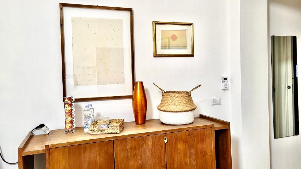 un mobile in legno con un vaso sopra di Volare House a Bari