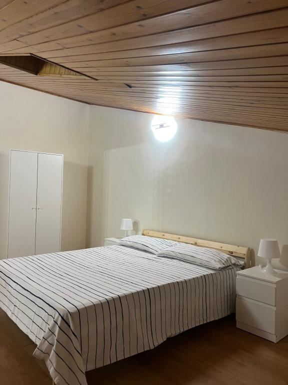 a bedroom with a large bed with a wooden ceiling at La mansarda di melo in Catania
