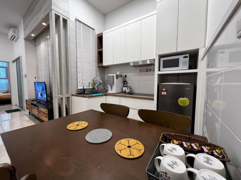 a kitchen with a table and a kitchen with a refrigerator at ITCC Manhattan Suites by Blossom37 in Donggongon