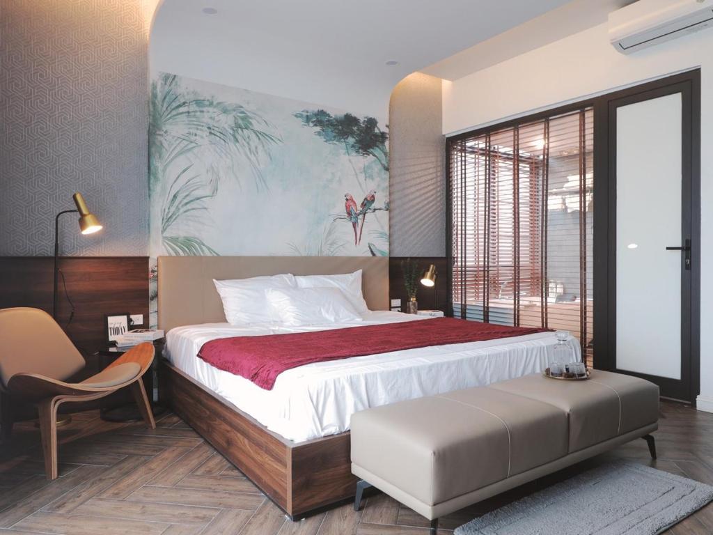 een slaapkamer met een groot bed en een stoel bij Moon Villa E2.10 Venus by Flamingo Đại Lải in Phúc Yên