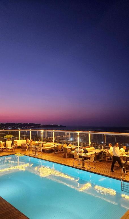 a swimming pool on the deck of a cruise ship at night at Dar El Marsa Hotel & Spa in La Marsa