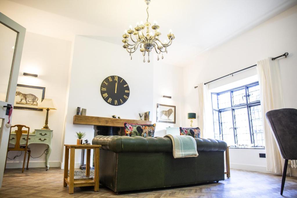 sala de estar con sofá y reloj en la pared en The Penthouse at Mercers Croft en Stratford-upon-Avon