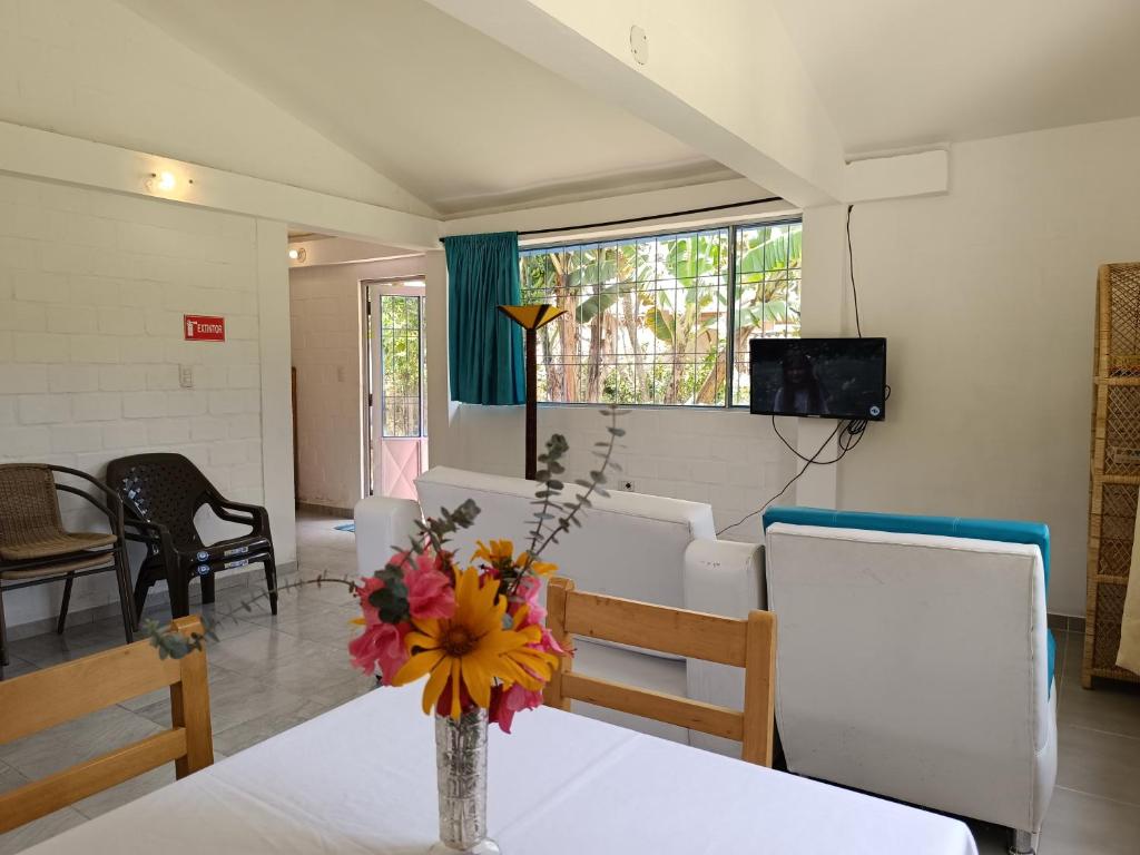 ChachagüíHOTEL PANORAMA SOL的房间里有一张桌子，桌子上放着一瓶花。