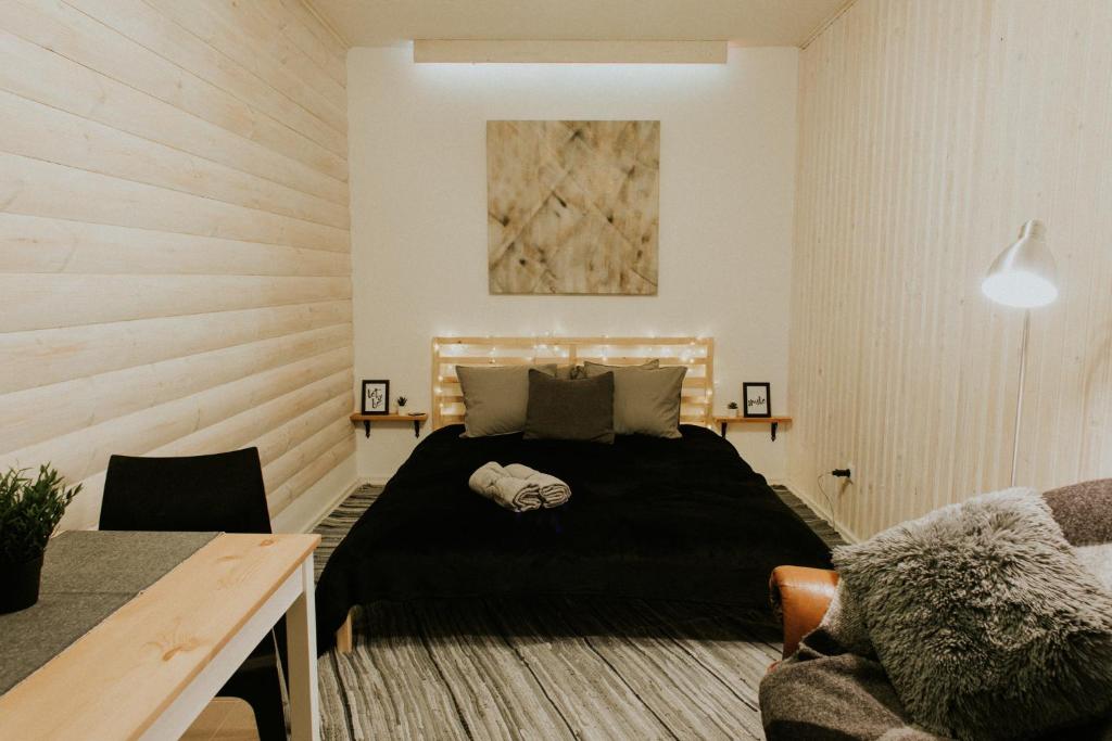 a bedroom with a black bed and a table at Sauna apartment / Pirts apartamenti in Talsi