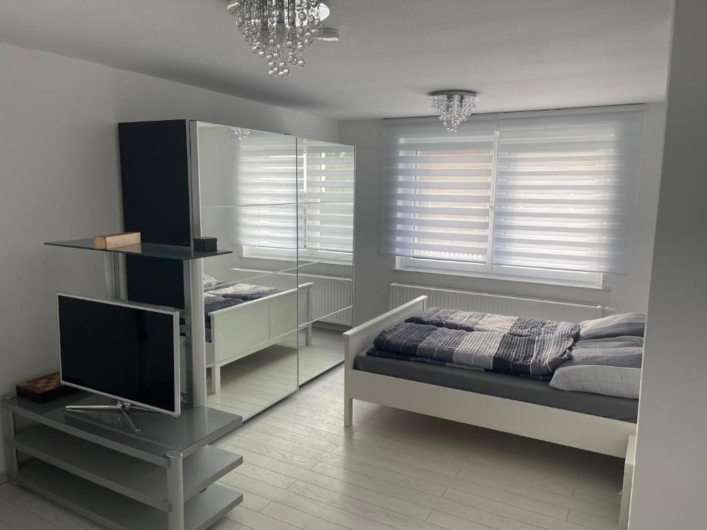 Un dormitorio con una cama y un televisor y ventanas. en Jürgenweg, Hannover, en Hannover