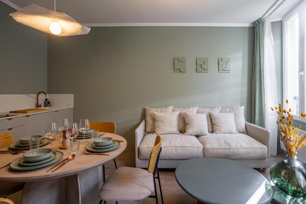 un soggiorno con tavolo e divano di The Liberty Green Suite a Parigi
