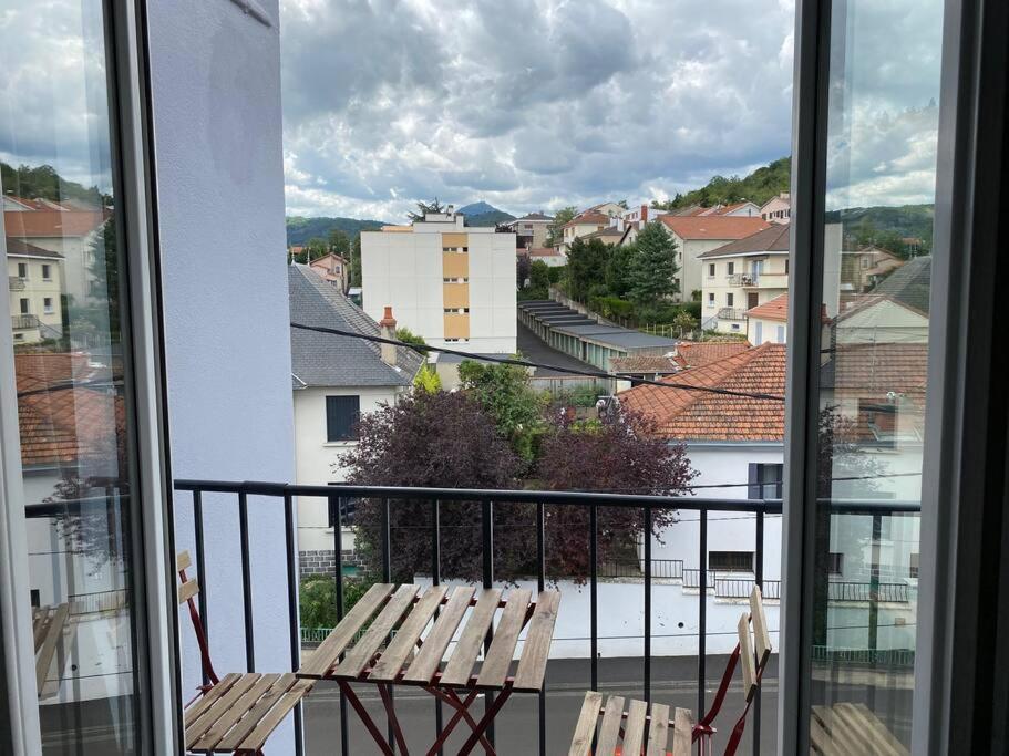 un balcon avec deux chaises et une vue sur une ville dans l'établissement Charmant 50m2 Clermont-ferrand vue Puy-de-Dôme, à Clermont-Ferrand
