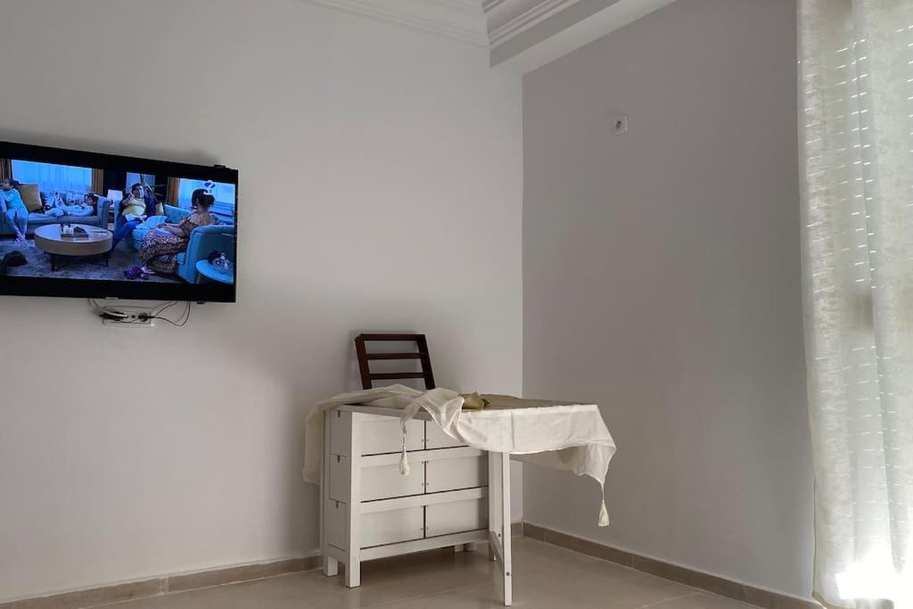 - un salon avec une télévision murale dans l'établissement Appartement T3 proche de la Plage !, à Jāmi‘ al Guelloufi