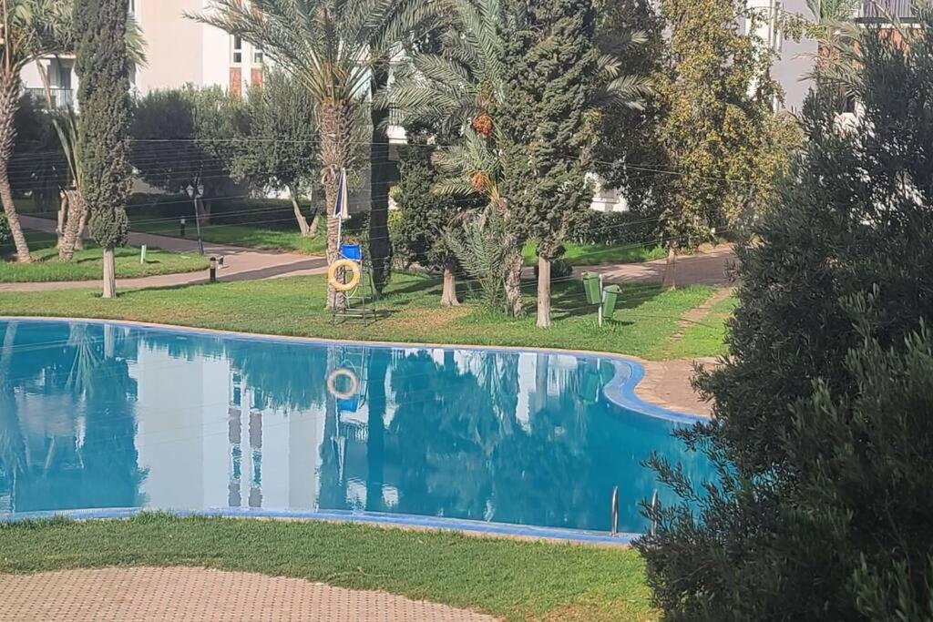 an empty swimming pool in a park with trees at Agadir Marina in Agadir