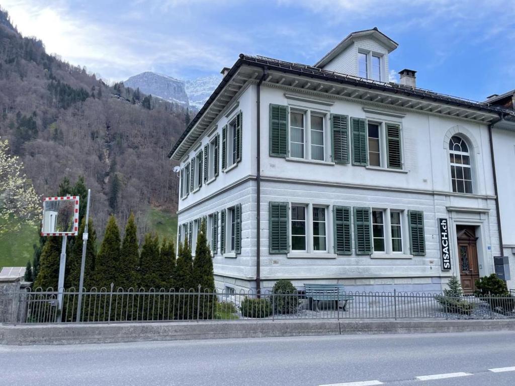 uma casa branca com persianas verdes e uma cerca em Revier Kanzlei im Hazzo em Hätzingen