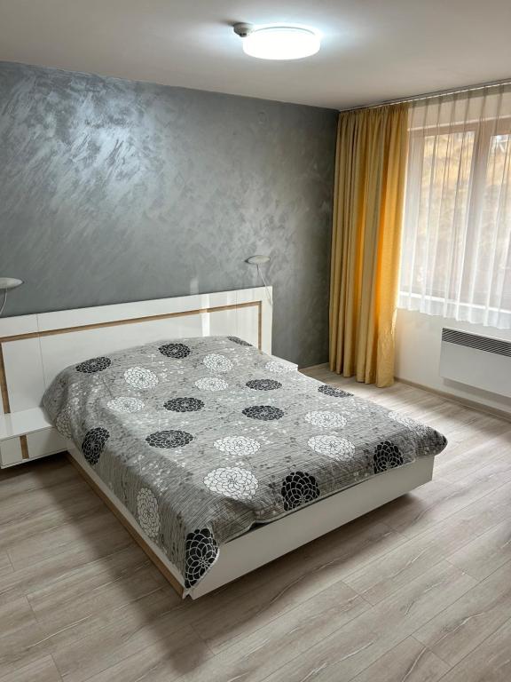 a bedroom with a bed with a quilt on it at Комплекс Замъка 2 ап 301 in Pamporovo