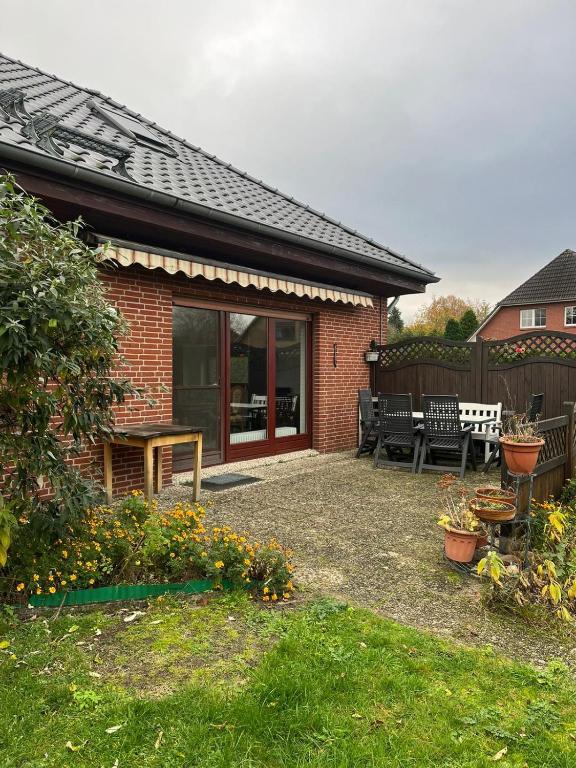 a brick house with a patio with a table and benches at Ferienhaus Heiderose in Schneverdingen
