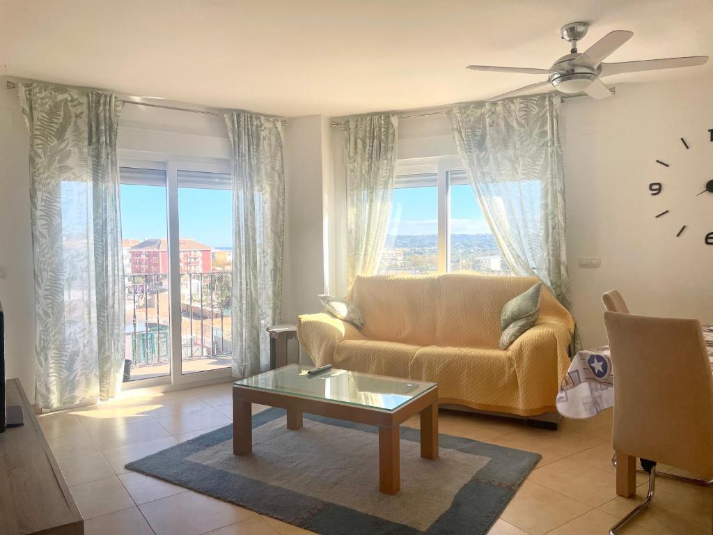 un soggiorno con un divano e un orologio a parete di El Faro a Jávea