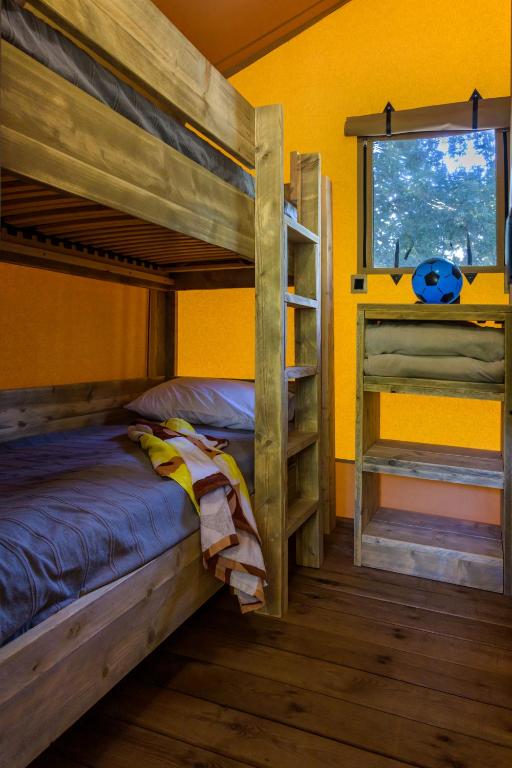 a bedroom with two bunk beds and a window at Camping U Pirellu in Porto-Vecchio