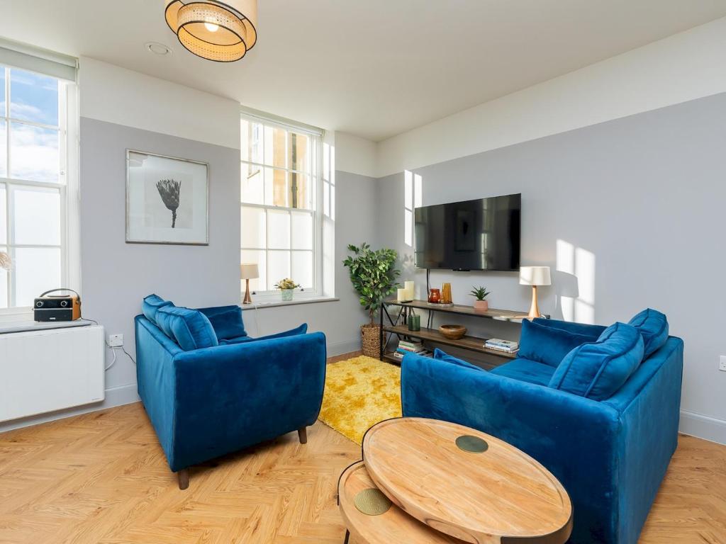 a living room with two blue chairs and a table at Pass the Keys Stunning 2 bed retreat in the heart of Bath in Bath