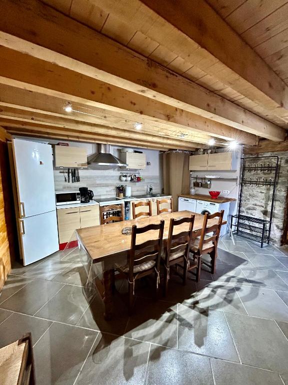 een keuken met een grote houten tafel en stoelen bij Chalet La Léchère in Valmeinier