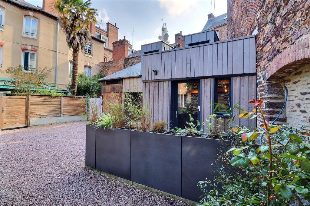 une maison noire avec des plantes sur son côté dans l'établissement Garden Hotel Rennes Centre Gare, à Rennes