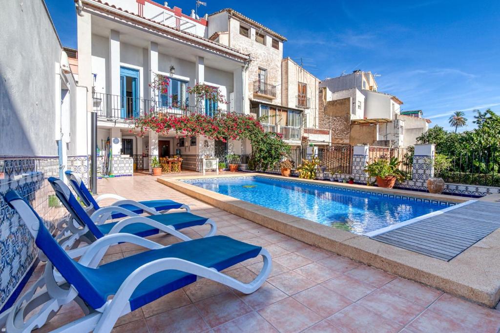 - une piscine avec des chaises longues à côté d'un bâtiment dans l'établissement Casa Lola Callosa, à Callosa d'en Sarrià