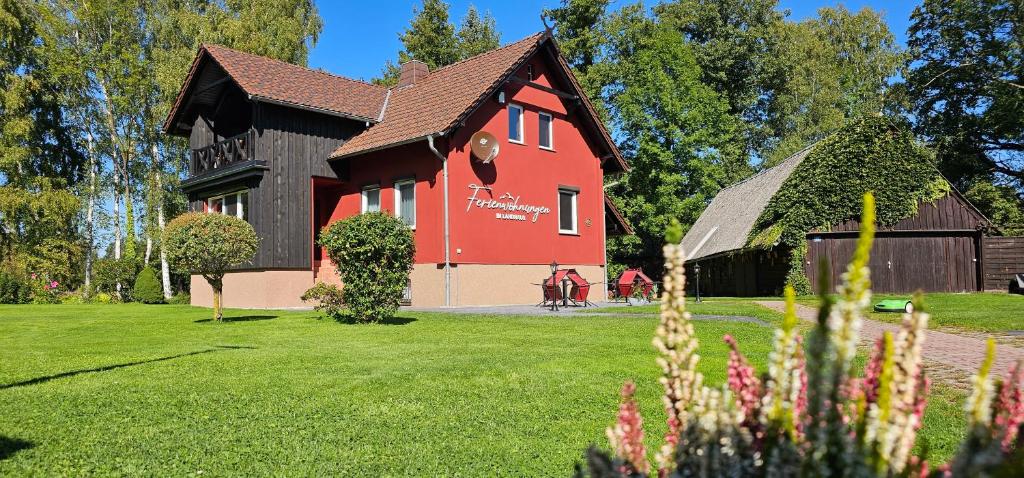 ブルクにあるFerienwohnungen im Landhausの庭の黒屋根の赤い家