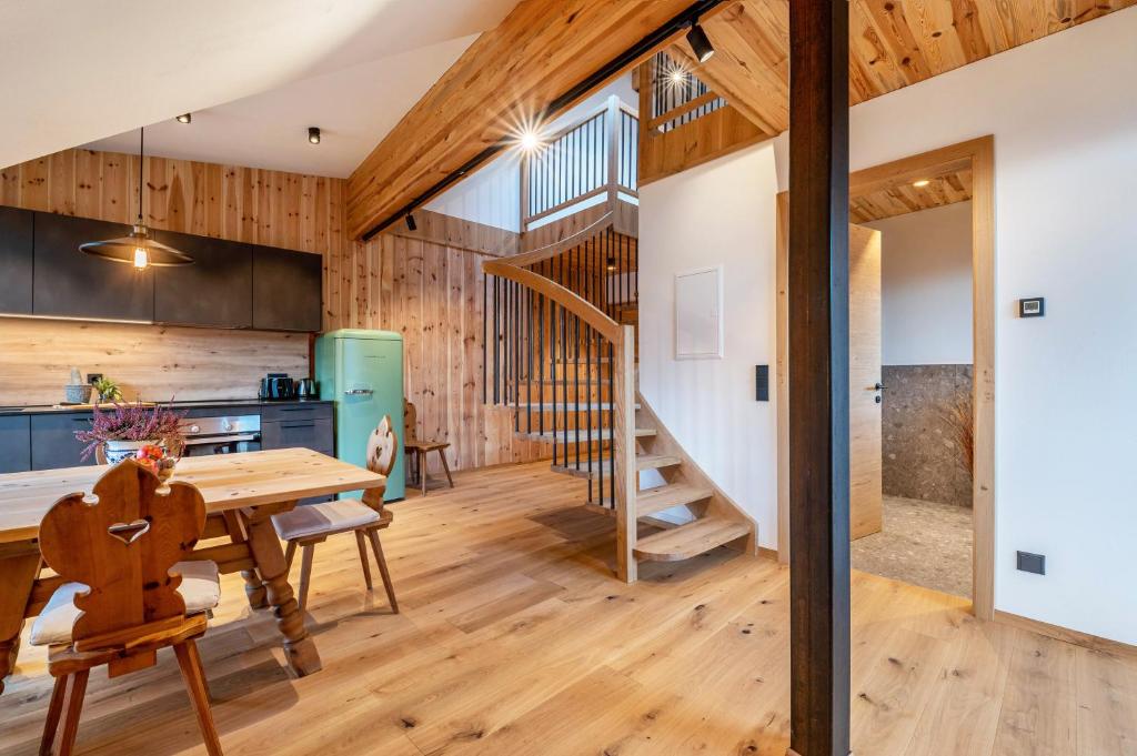 a kitchen and dining room with a table and a staircase at Rotwandterhof Wohnung Bienenstock in Barbiano