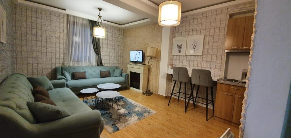a living room with a couch and a table and a kitchen at Mujen Lux Kopaonik - Superior Apartman in Kopaonik