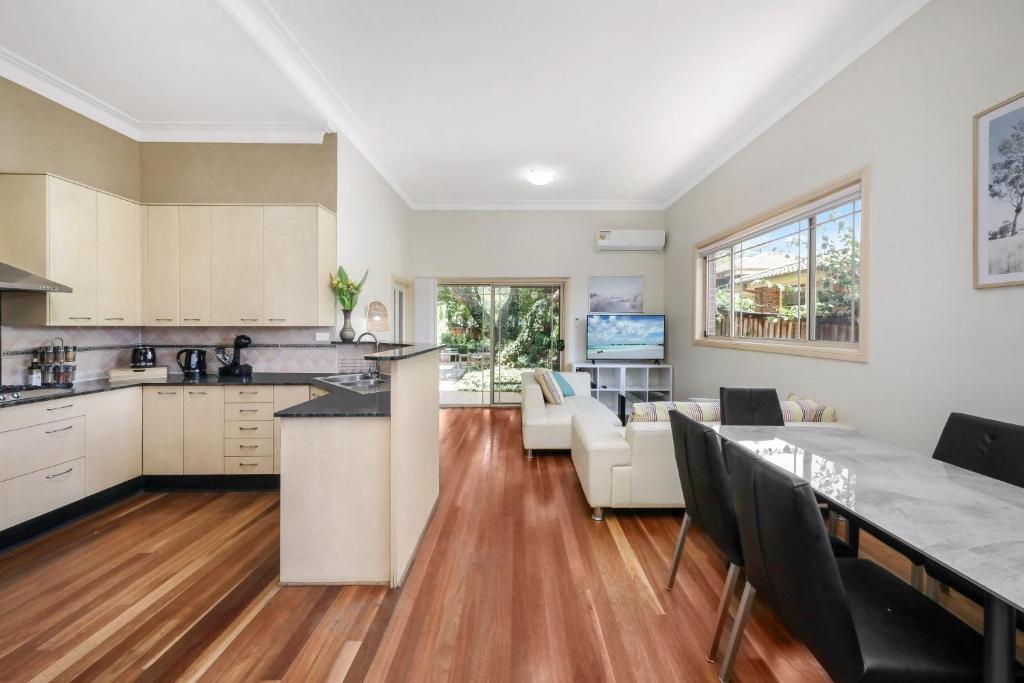 a kitchen and living room with a table and chairs at Eastwood Central, Walk to Station & Shops, Drive to Olympic in Sydney