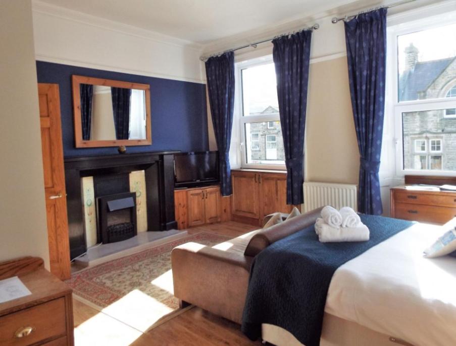 a bedroom with a bed and a fireplace at The Board Inn in Hawes
