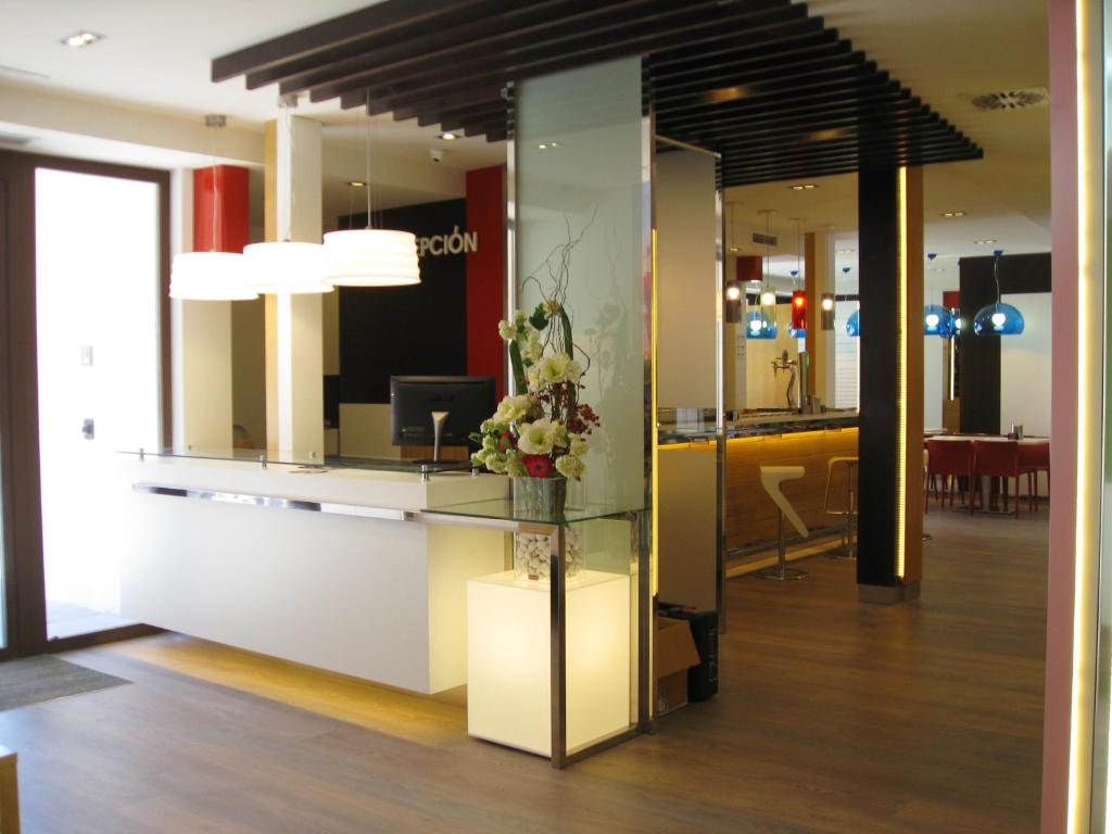 a lobby with a reception desk with flowers on it at Hotel Boutique Museo Burgos in Burgos
