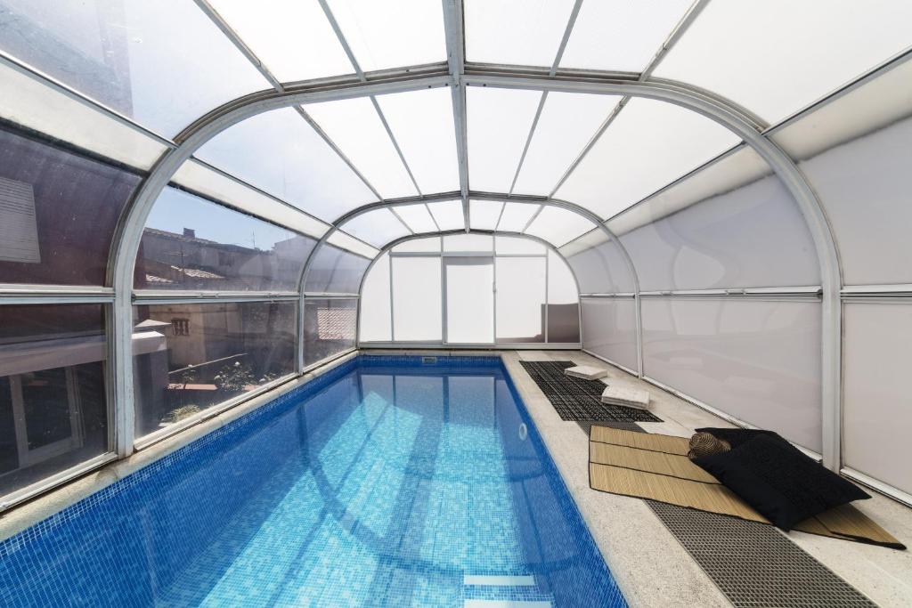 une piscine intérieure avec un plafond en verre dans l'établissement La casa del Piano, à Figueres