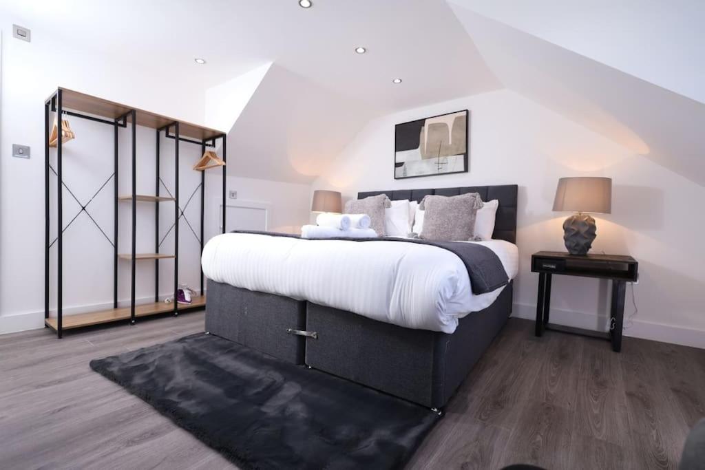 1 dormitorio con 1 cama grande con sábanas blancas en PrimeLocation! Spacious 4BR Apt Market St Watford!, en Watford