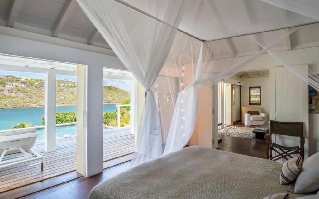 um quarto com uma cama e vista para o oceano em Saint Barth Villa 10 em Marigot