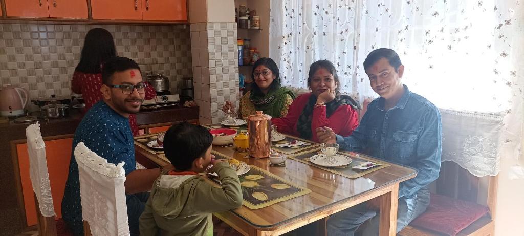 a group of people sitting around a table at Valley View Homestay in Darjeeling
