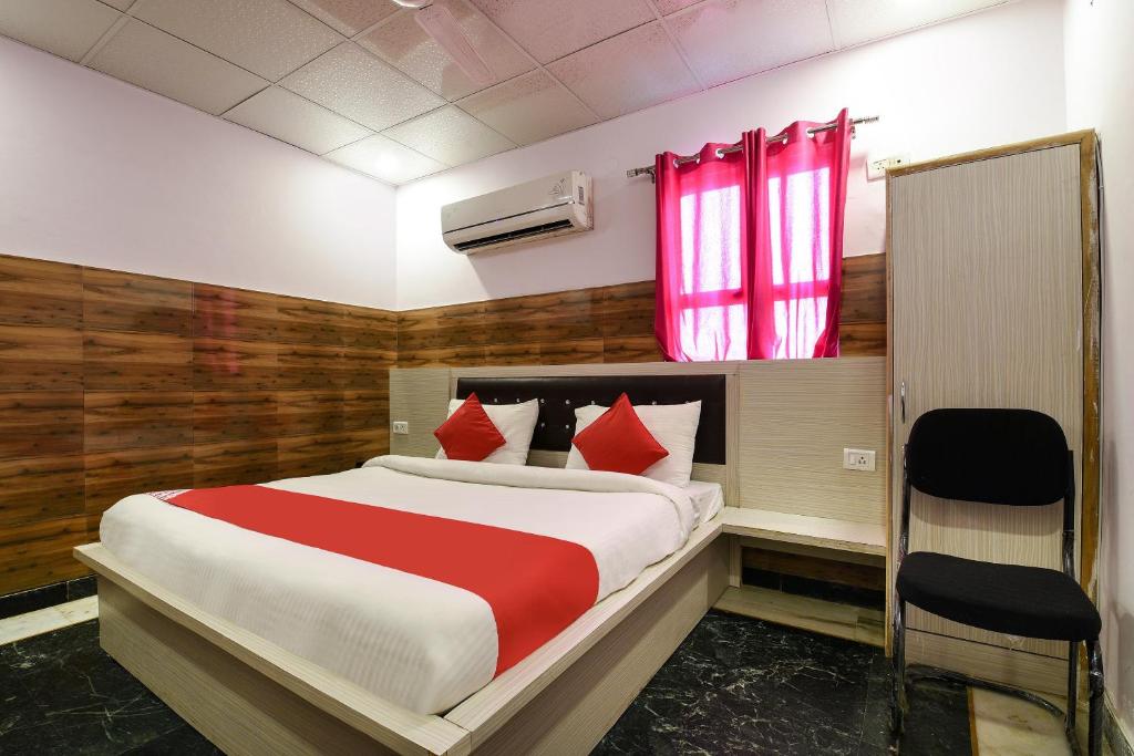 1 dormitorio con 1 cama grande con almohadas rojas en Collection O 13772 hotel krishna, en Noida