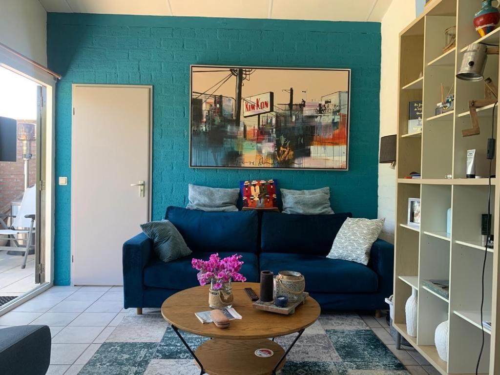 sala de estar con sofá azul y mesa en Rekerlanden 211, en Warmenhuizen